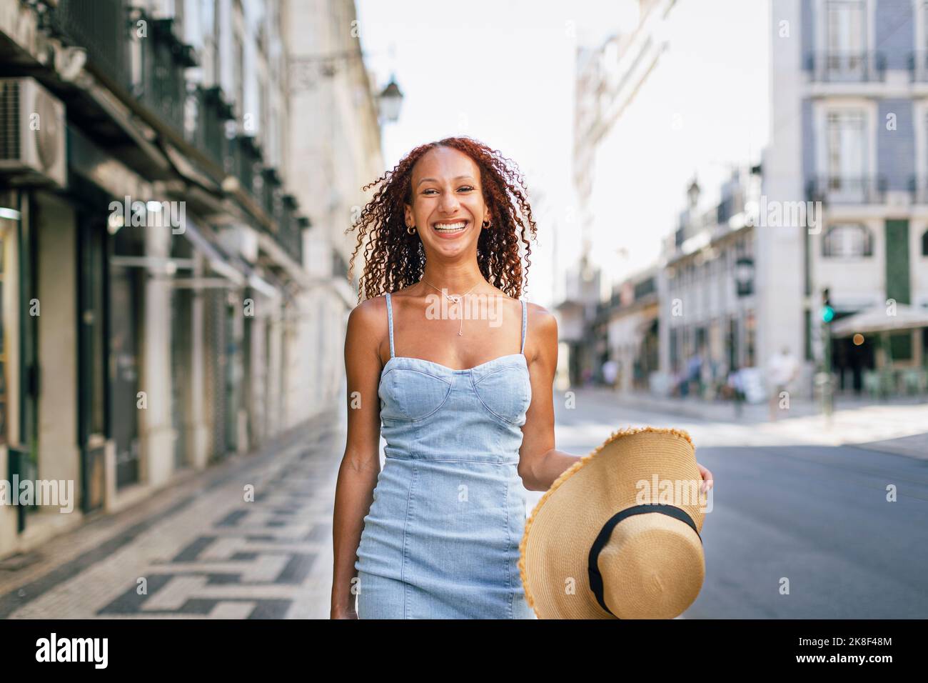 Glückliche junge Frau mit Hut am Fußpfad Stockfoto