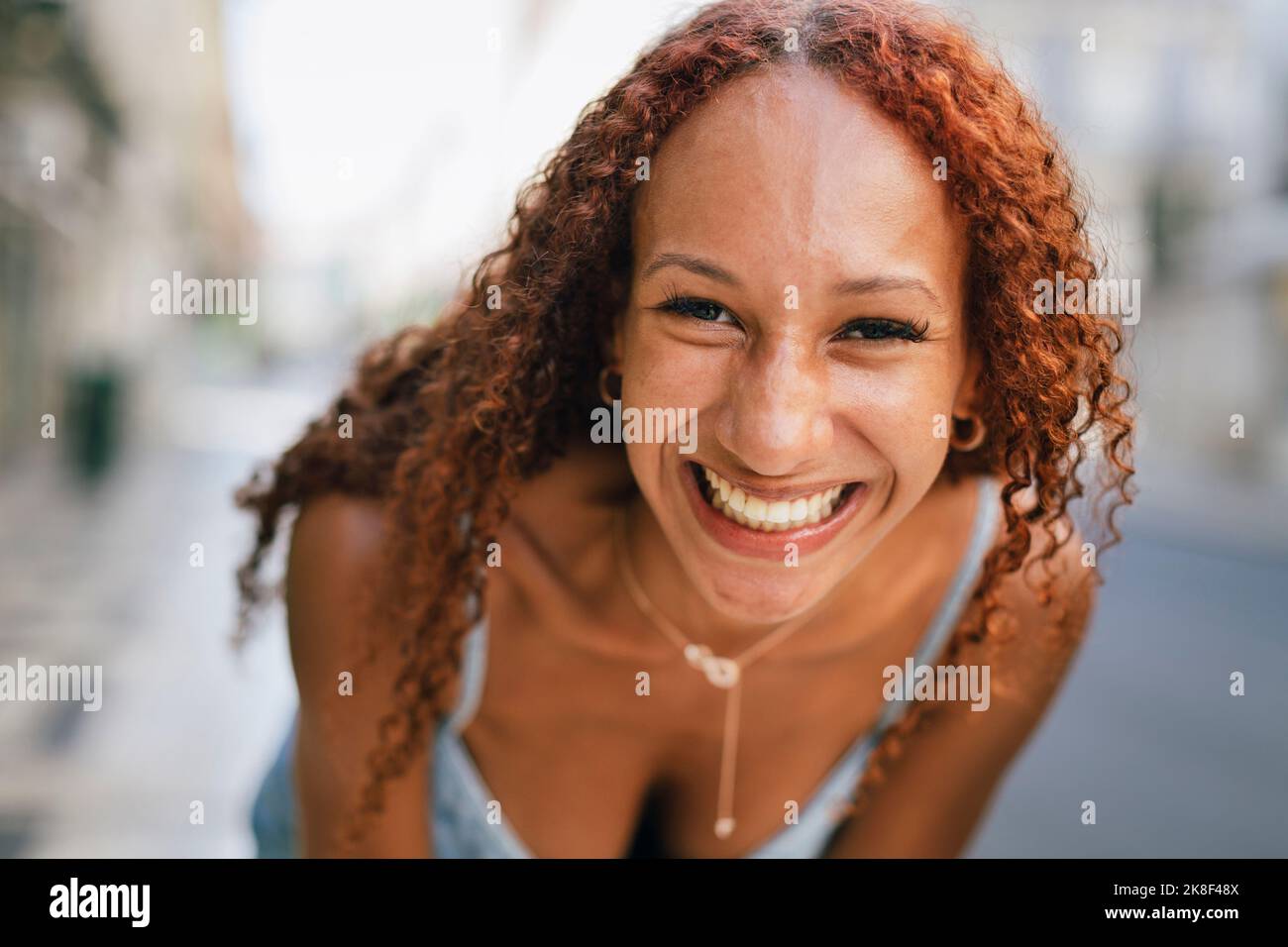 Fröhliche junge Frau mit lockigen Haaren Stockfoto