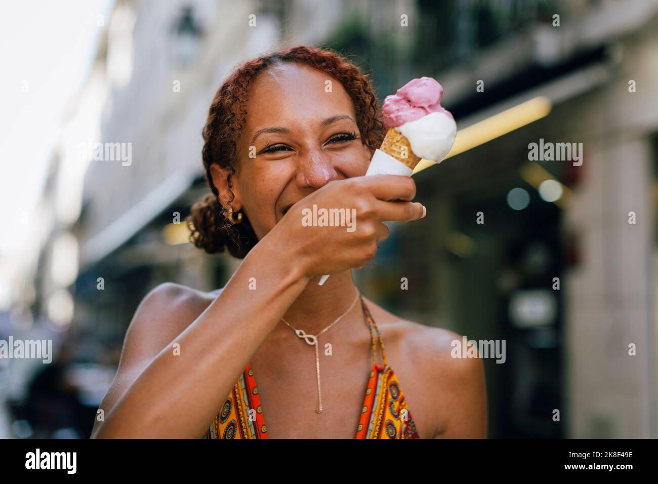 Fröhliche junge Frau, die Eis genießt Stockfoto
