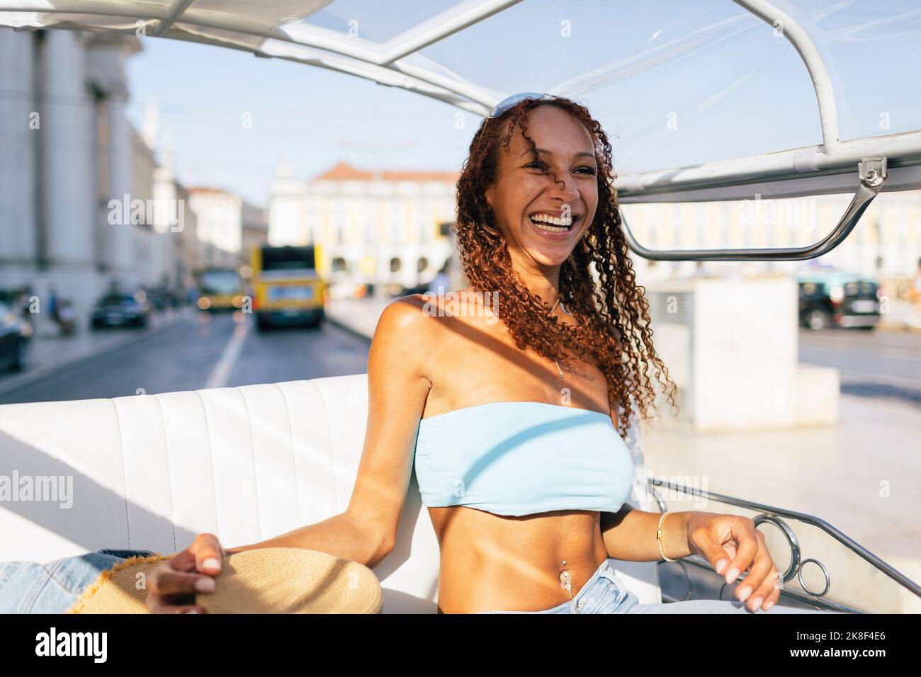 Glückliche junge Frau, die an einem sonnigen Tag Tuk Tuk Ride macht Stockfoto