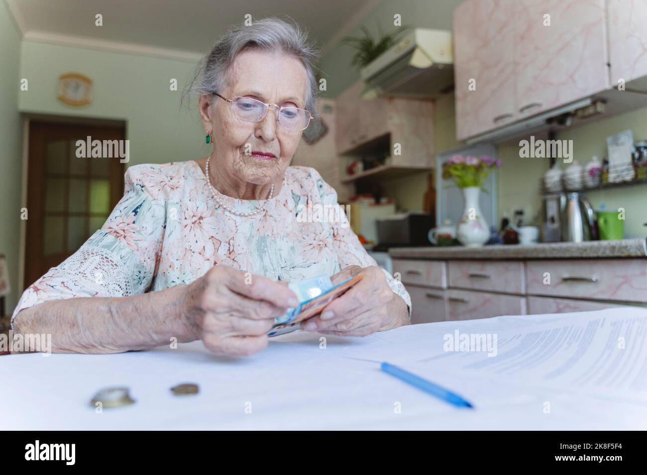 Ältere Frau, die zu Hause Papiergeld zählt Stockfoto