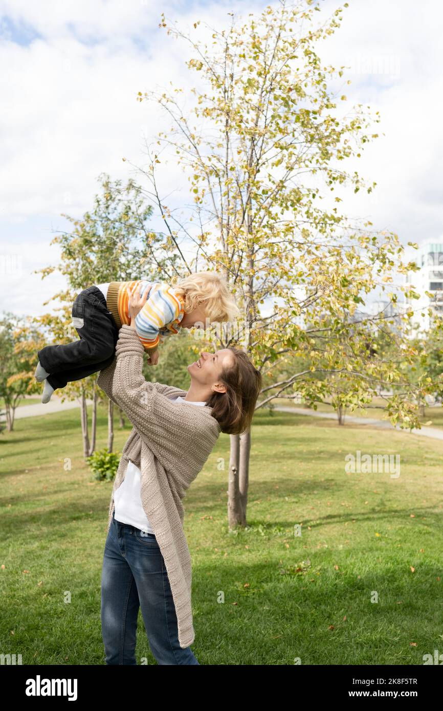 Glückliche Mutter, die mit dem Sohn im Park spielt Stockfoto