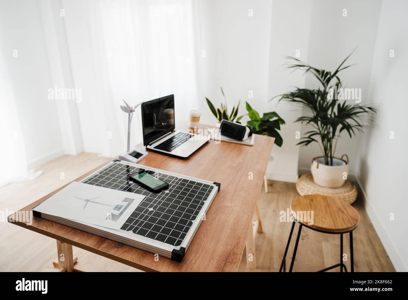 Tragbares Solarpanel- und Windturbinenmodell auf dem Schreibtisch des Technikers Stockfoto