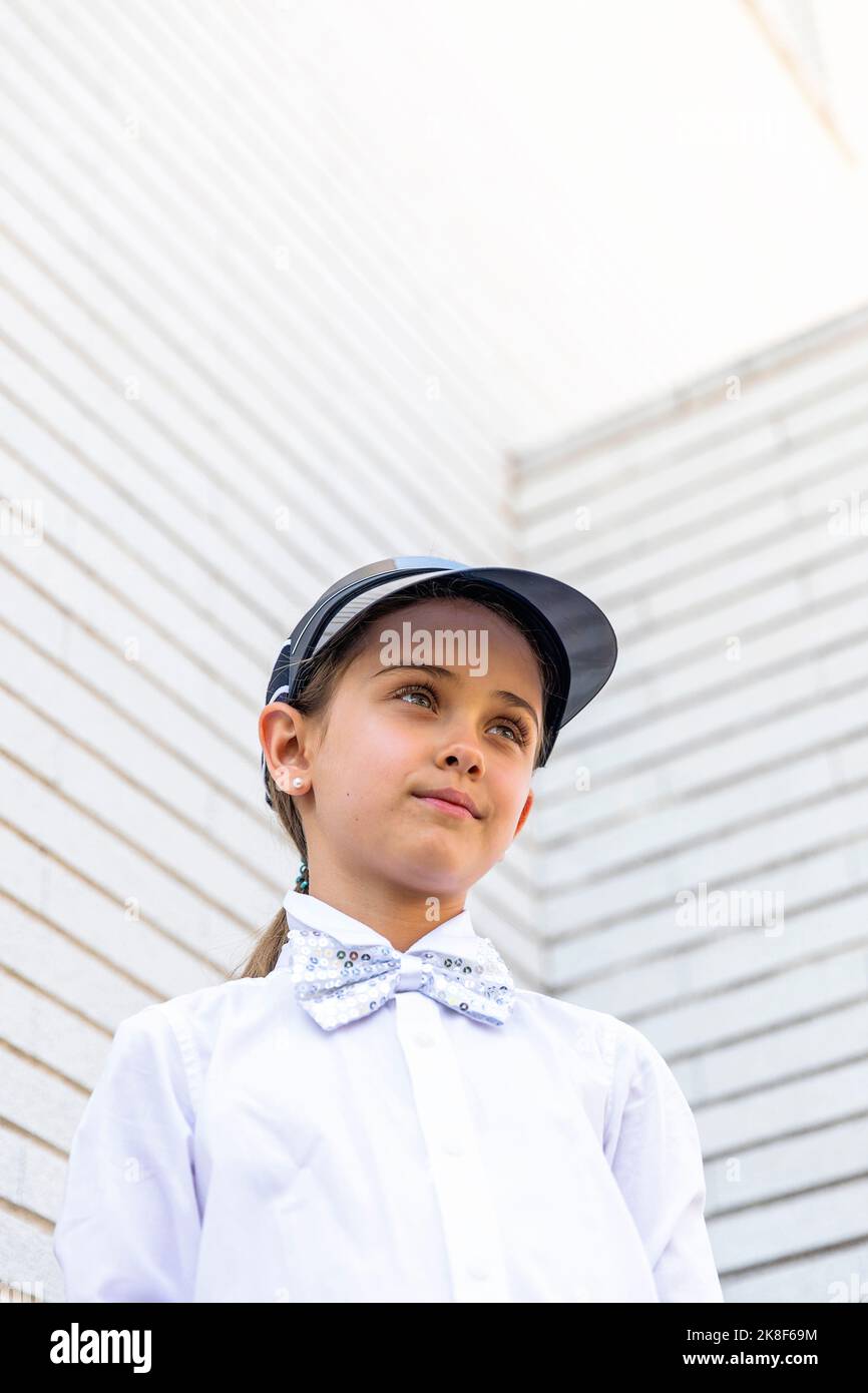 Mädchen trägt Sonnenblende vor der weißen Wand stehen Stockfoto