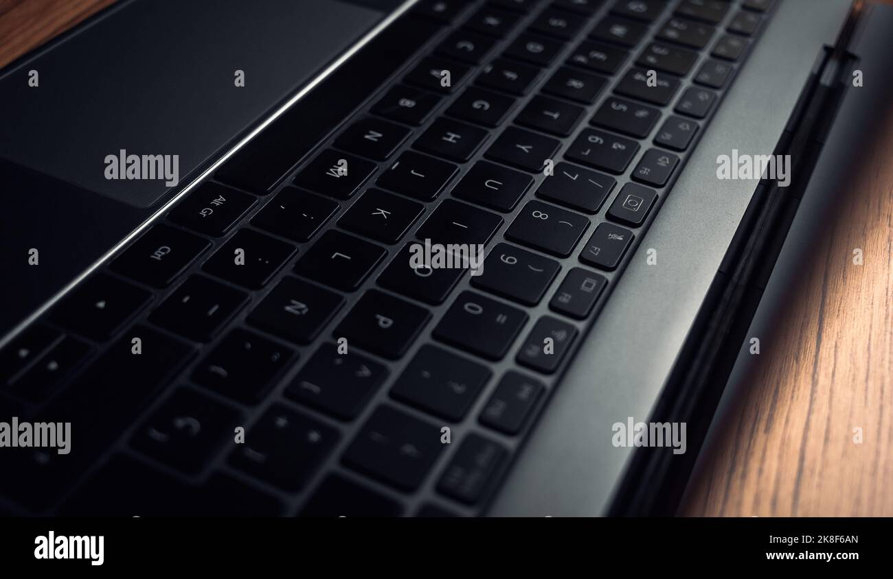 Horizontales Foto der Laptop-Tastatur in dunklen Stimmungstönen. Business und Finanzen. „Work from Home“-Konzept. Technologie-Tastatur mit Kopierplatz. Stockfoto