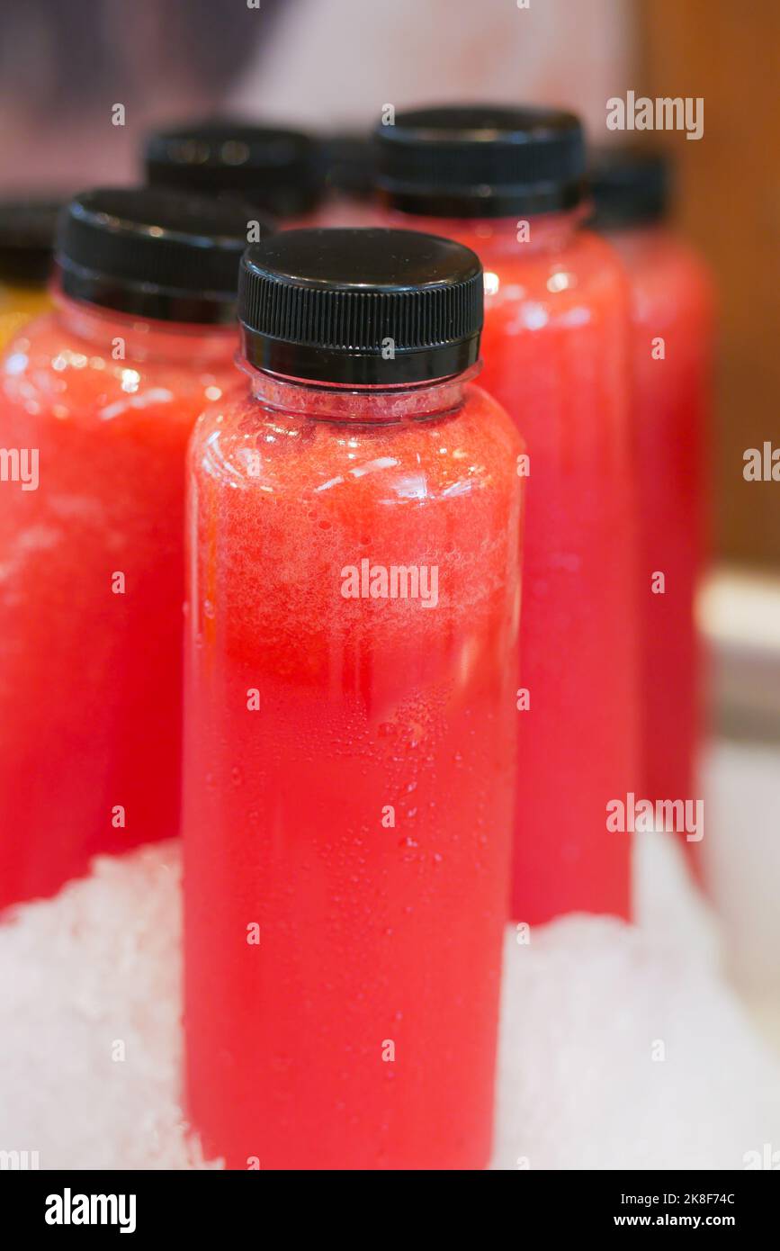 Plastikflaschen aus rotem Softdrink in Eis Stockfoto