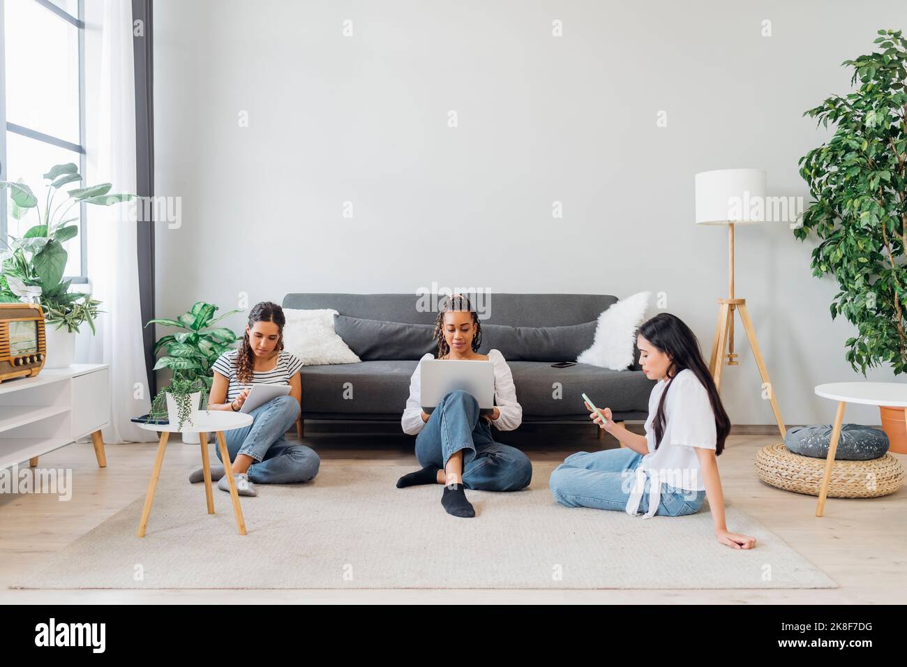 Junge Mitbewohner nutzen Technologien im Wohnzimmer zu Hause Stockfoto