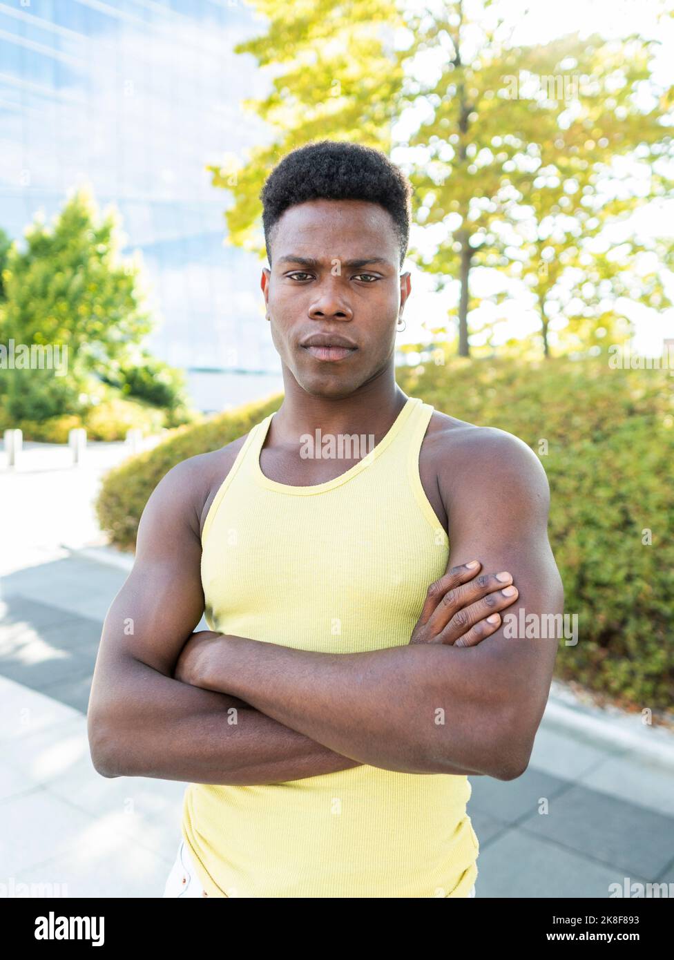Selbstbewusster junger Mann mit gelber Weste und gekreuzten Armen Stockfoto