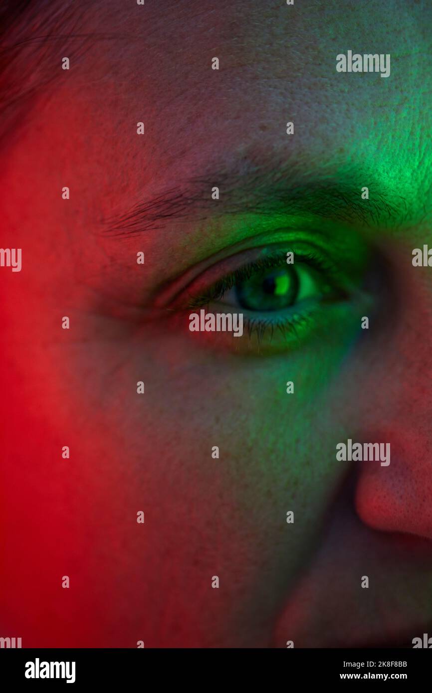 Auge der Frau mit Reflexion von rotem und grünem Licht Stockfoto