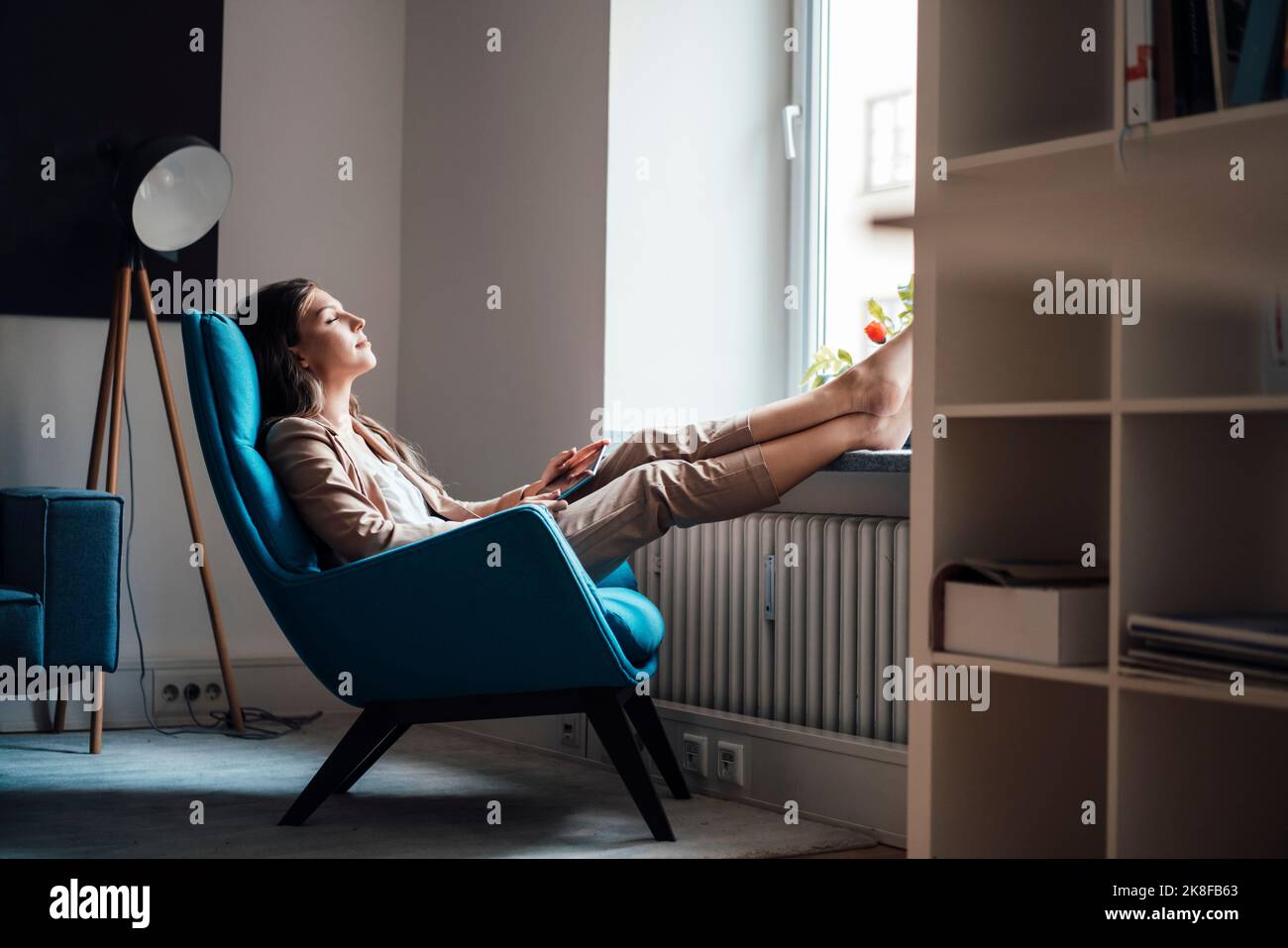 Geschäftsfrau, die sich zu Hause auf dem Stuhl entspannt Stockfoto