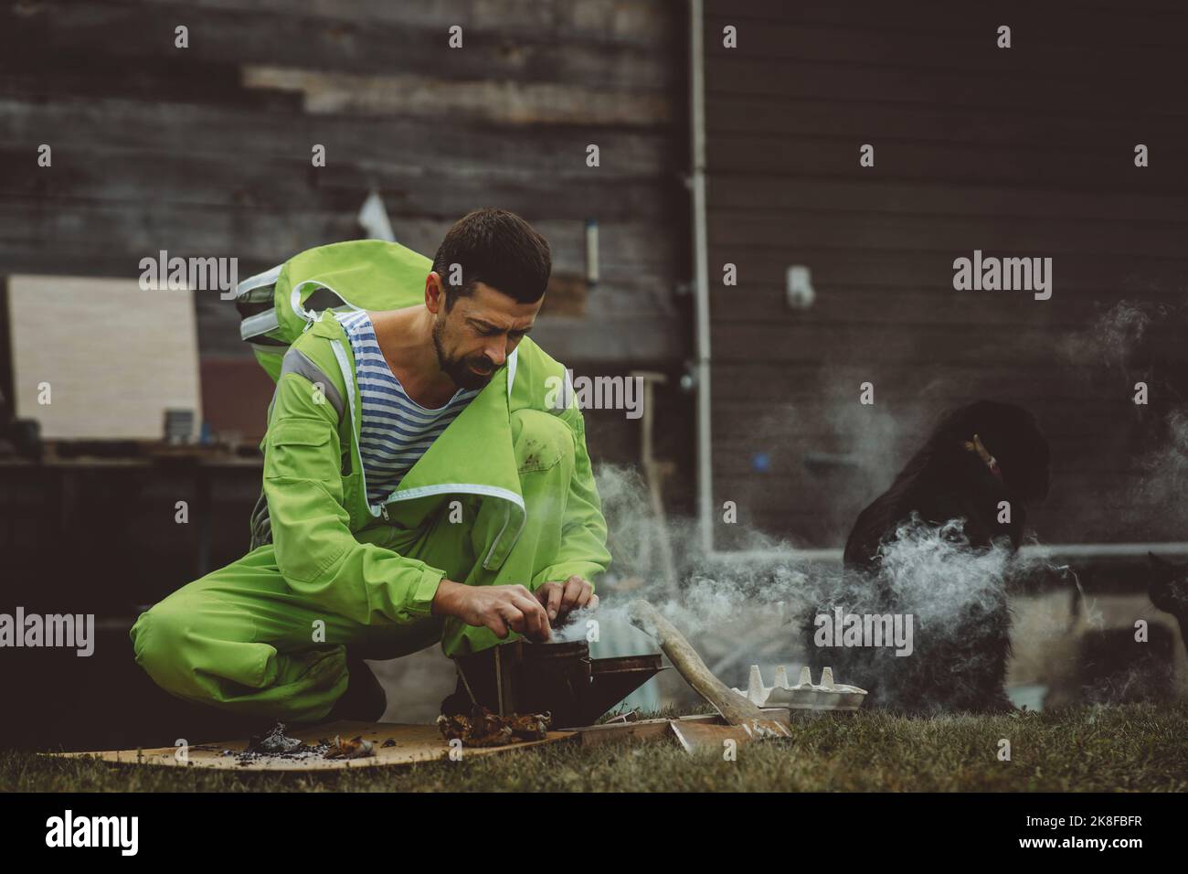 Reifer Imker, der Zunder-Pilz in Bienenmüchtern verbrennt Stockfoto