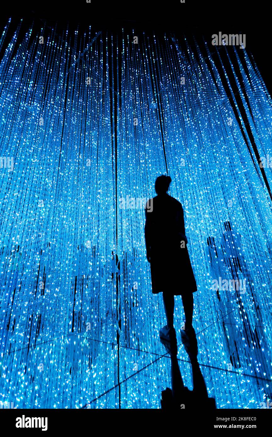 Frau und andere Menschen im illuminierten virtuellen Multiversum-Konzept Stockfoto