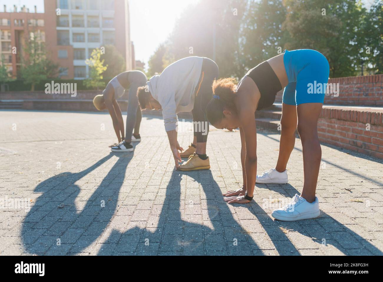 Junge Sportfreunde üben Bewegung auf dem Fußweg Stockfoto