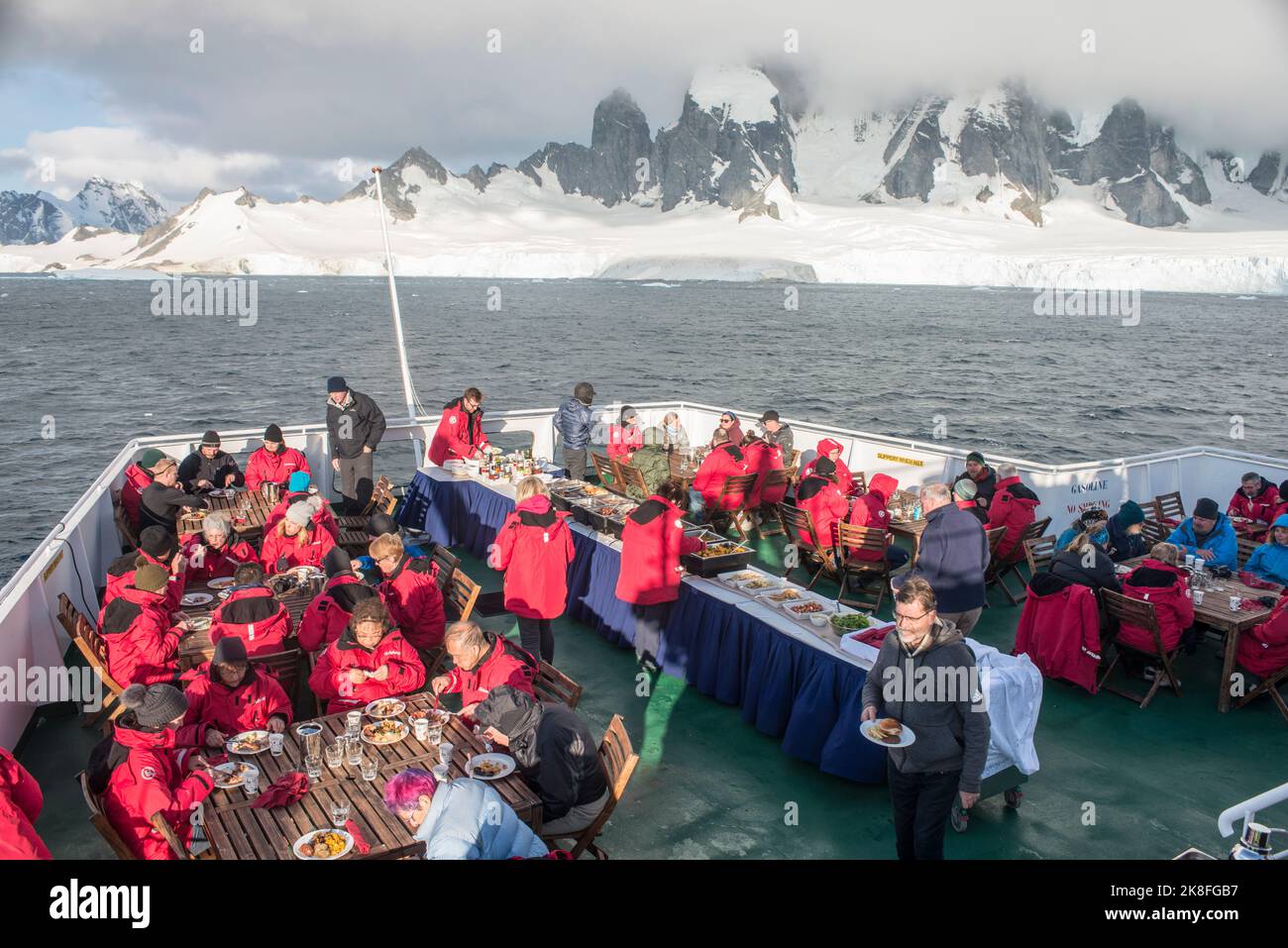 Kreuzfahrt-Expeditionsgast essen an Deck des Schiffes Expedition am Georges Point , Antarktische Halbinsel, Stockfoto