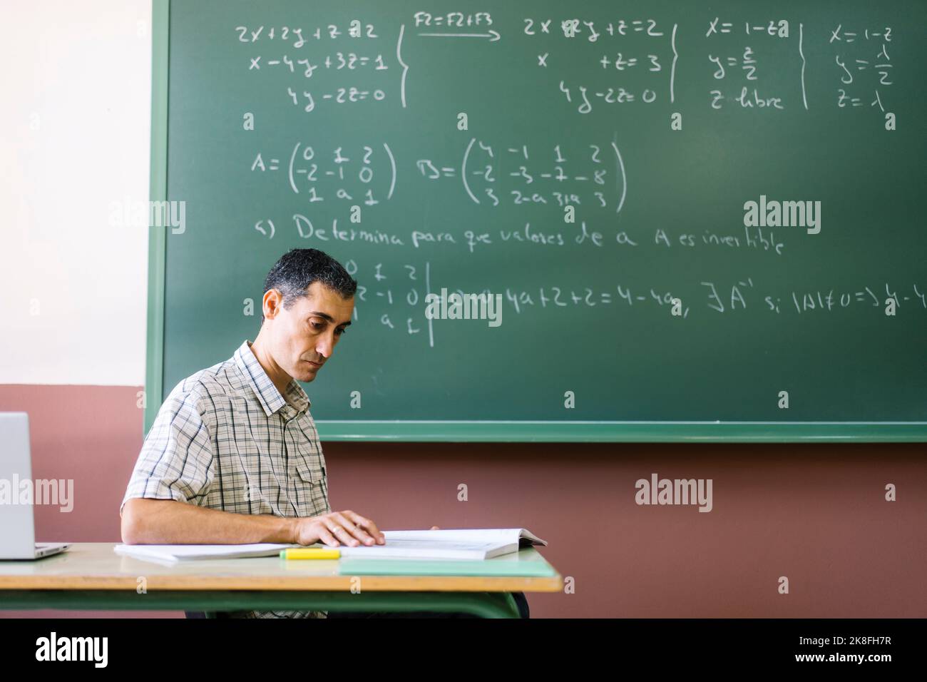 Mathelehrerin liest Buch im Klassenzimmer Stockfoto