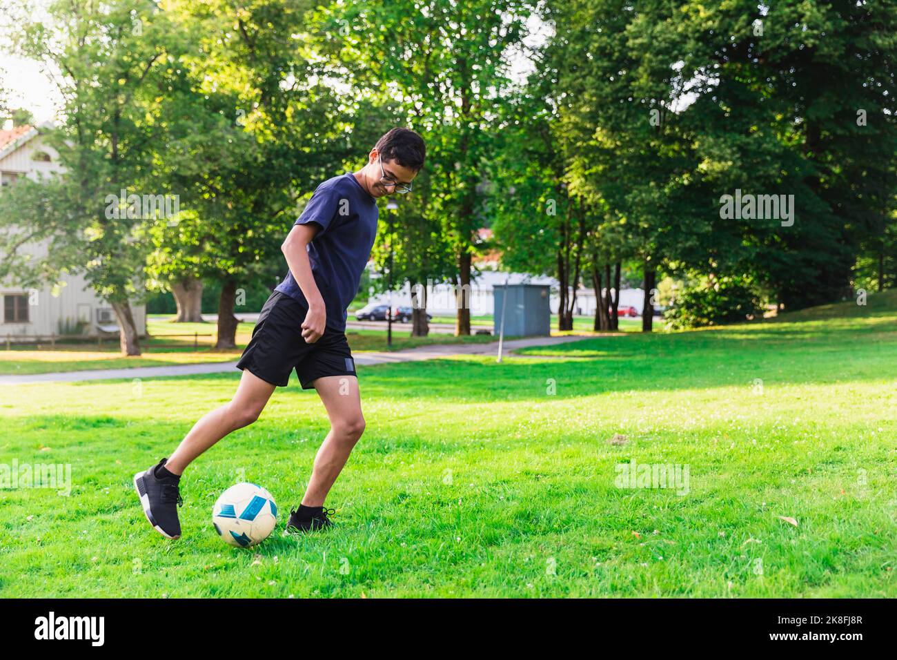 Junge spielt Fußball auf Gras im Rasen Stockfoto