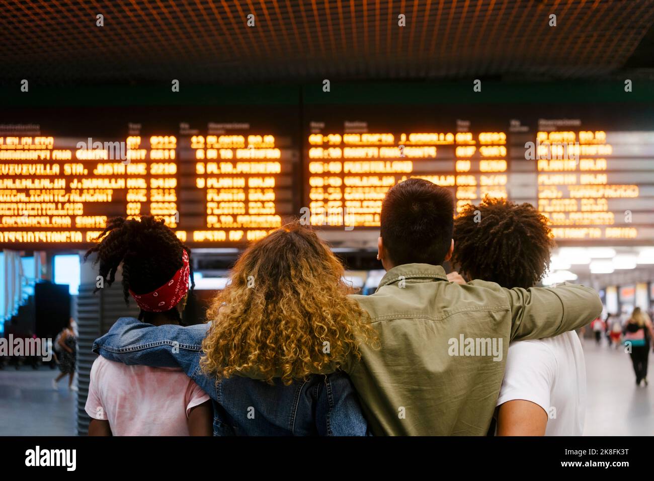 Multirassische Freunde überprüfen die Zeit an der Abfahrt am Bahnhof Stockfoto