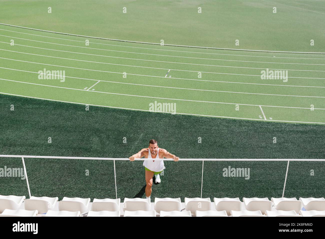 Sportler trainieren auf Geländer auf Sportplatz Stockfoto