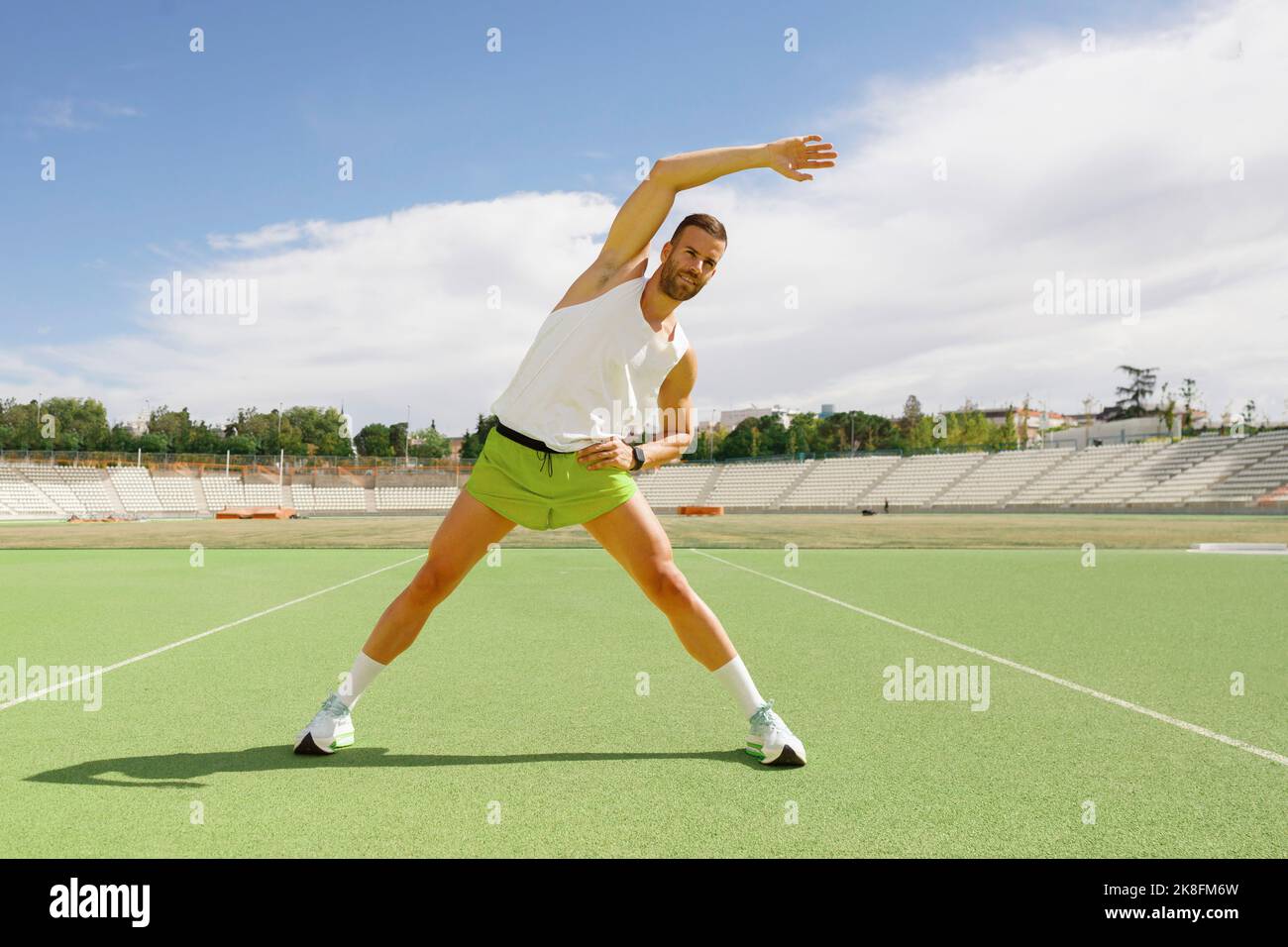 Sportler, der Stretching-Übungen auf dem Sportplatz praktiziert Stockfoto
