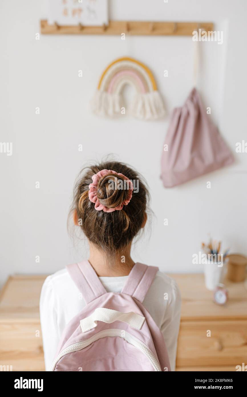 Rückansicht des Mädchens mit pinkem Rucksack und Haarknoten Stockfoto
