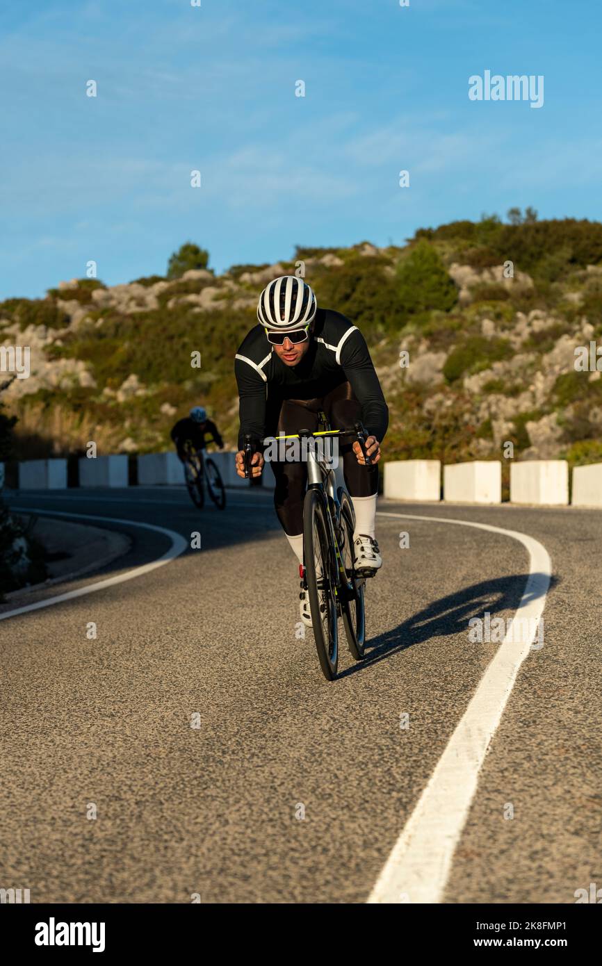 Entschlossener Radfahrer, der vom Bergpass der Costa Blanca in Alicante, Spanien, abfährt Stockfoto