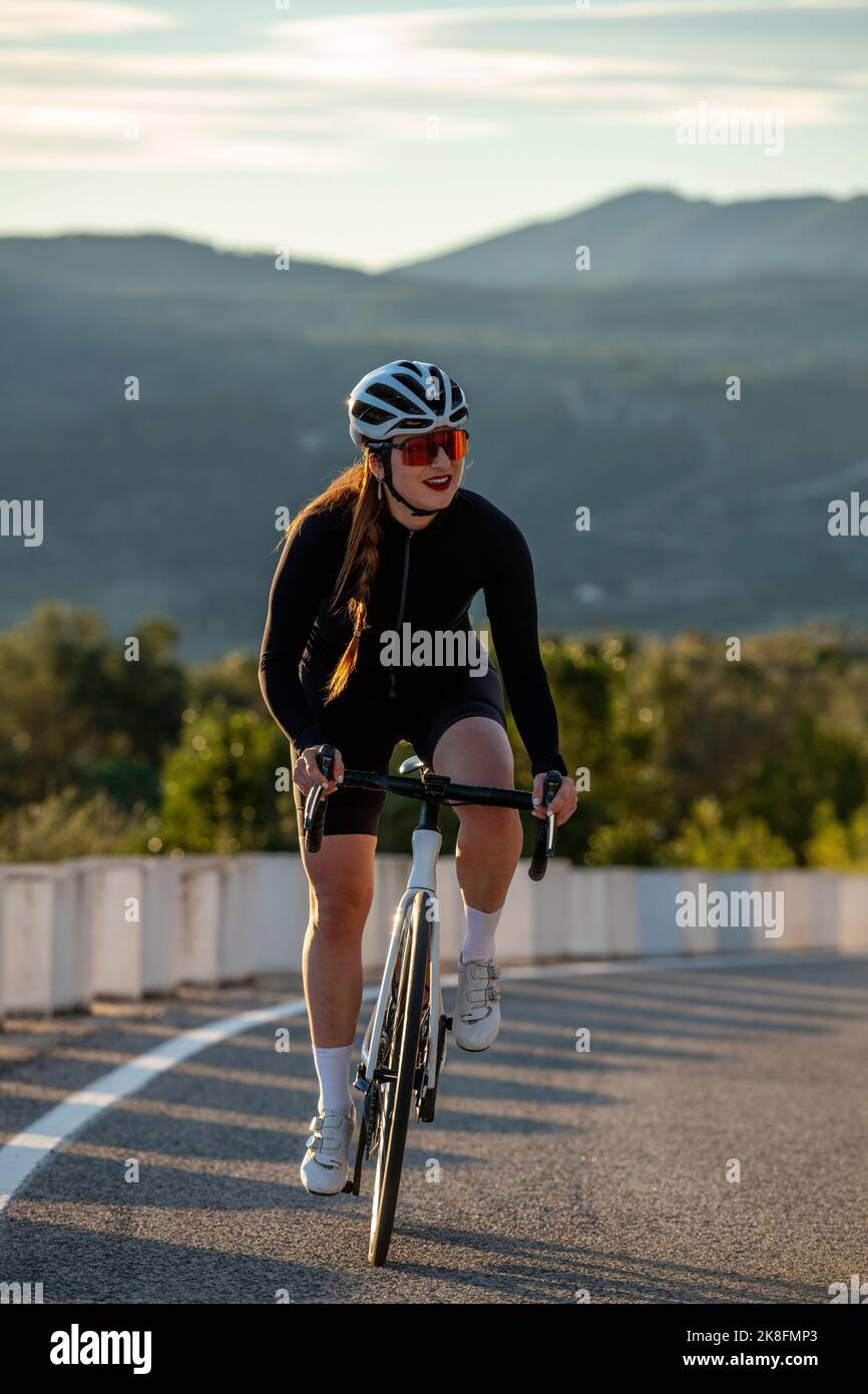 Lächelnde Sportlerin beim Radfahren auf dem Bergpass der Costa Blanca in Alicante, Spanien Stockfoto