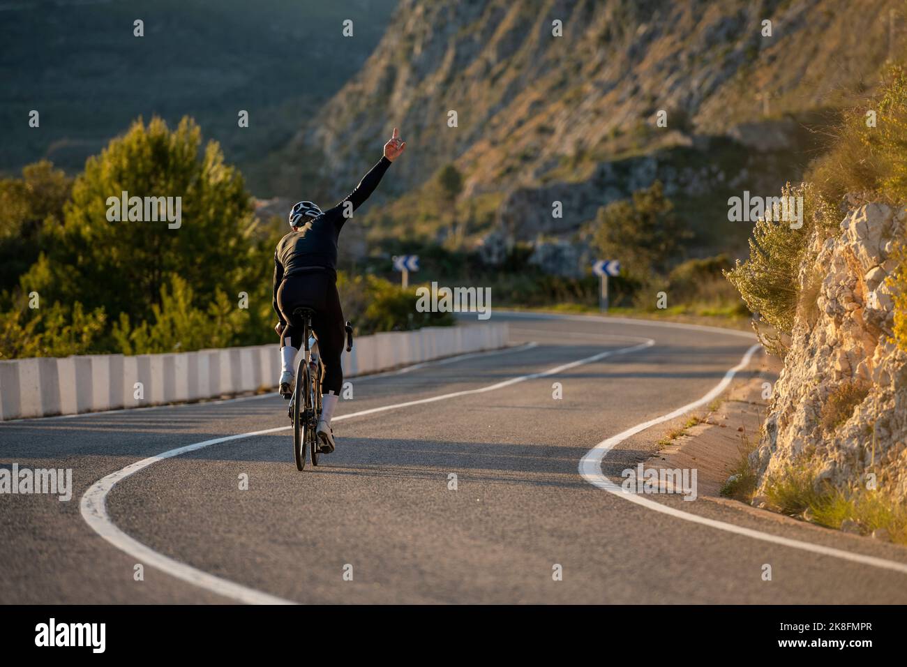 Radler mit handgehobener Radtour auf der Straße am Bergpass der Costa Blanca in Alicante, Spanien Stockfoto