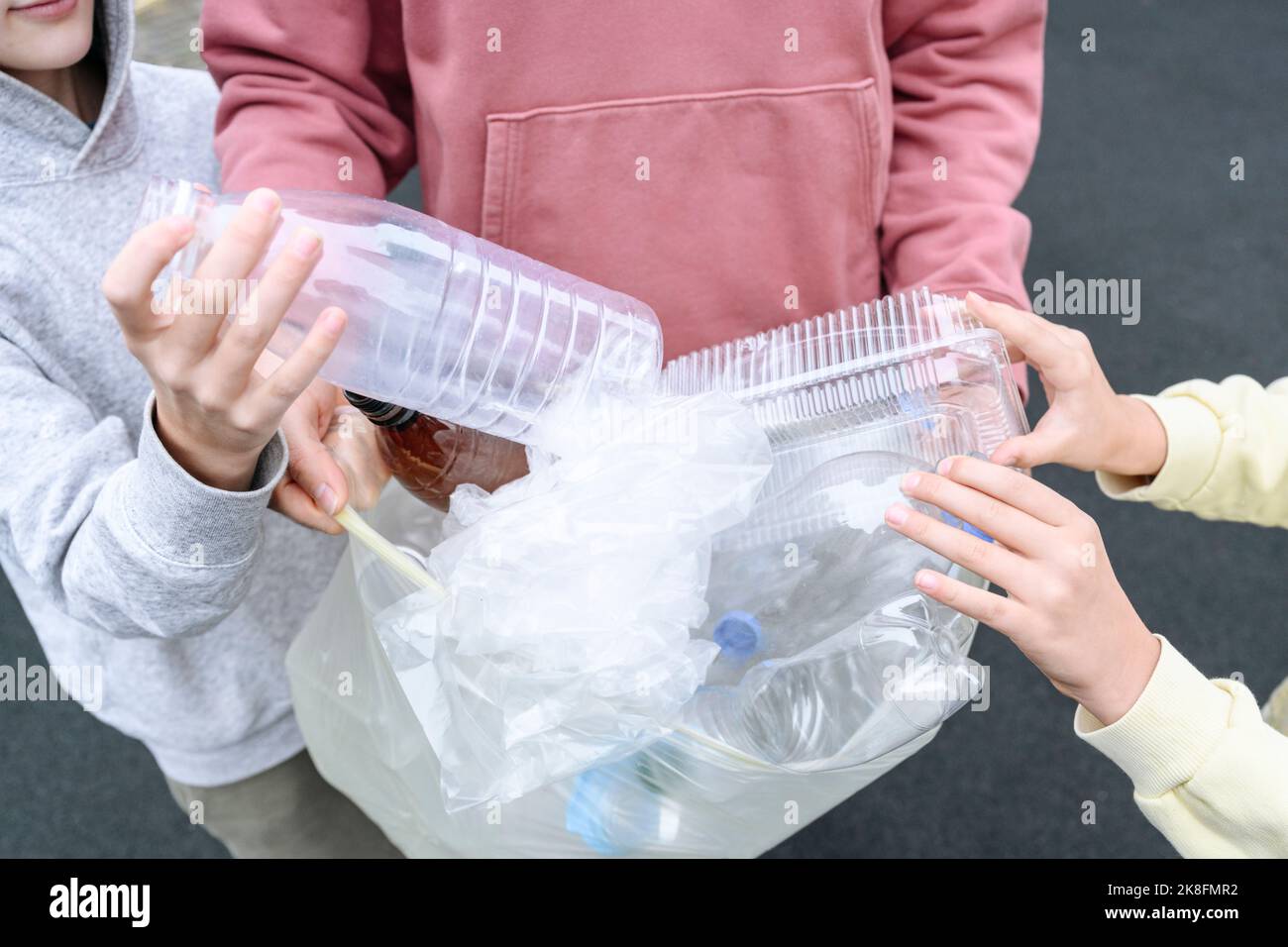 Hände von Menschen und Kindern sammeln Plastikmüll Stockfoto