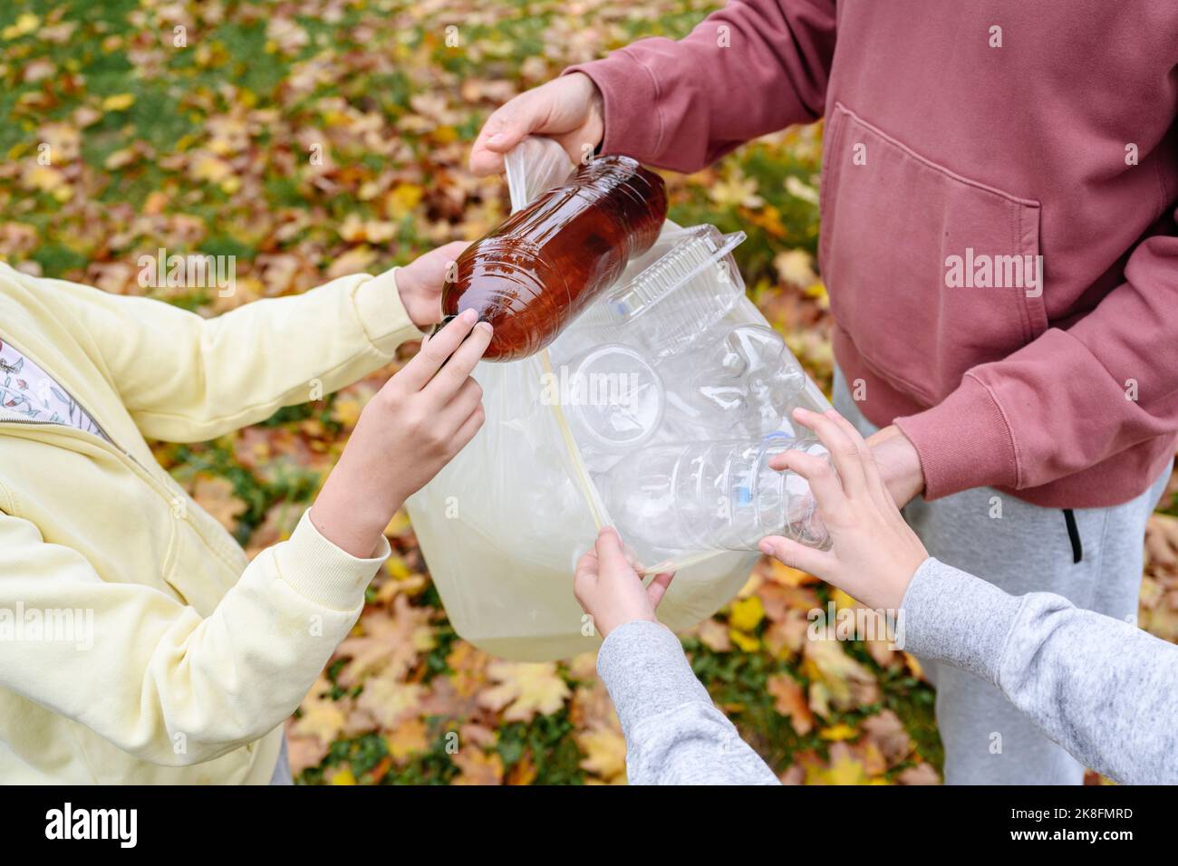 Hände von Menschen und Kindern sammeln Plastikmüll Stockfoto
