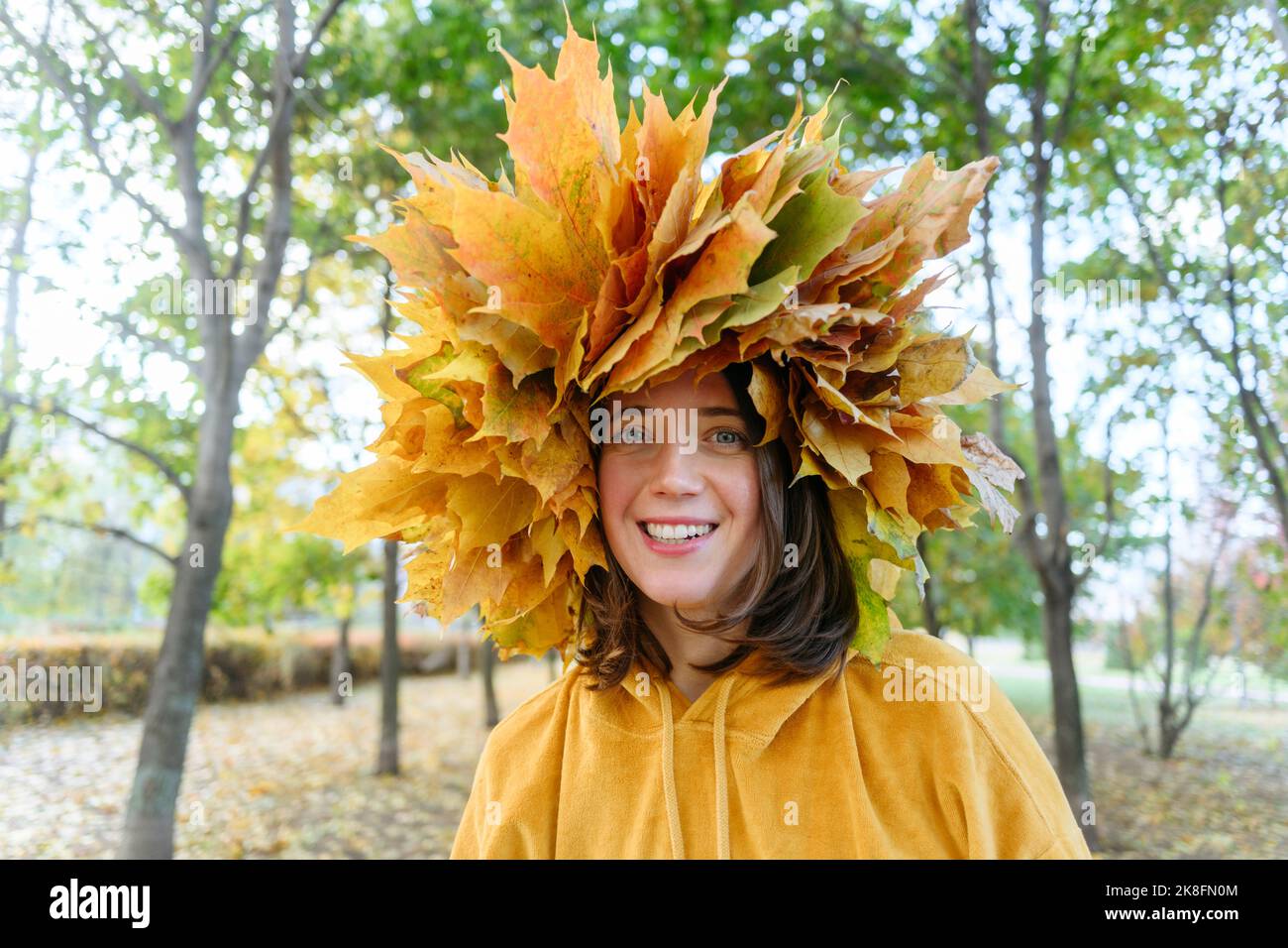 Glückliche Frau mit Herbstkranz auf dem Kopf Stockfoto