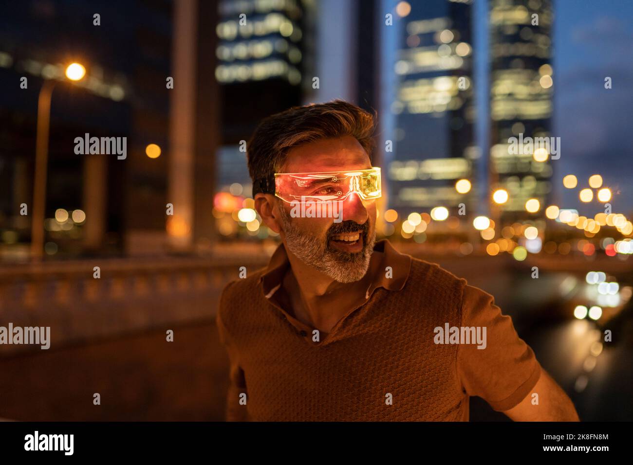 Aufgeregter Geschäftsmann in einer schicken Brille in der Stadt in der Nacht Stockfoto