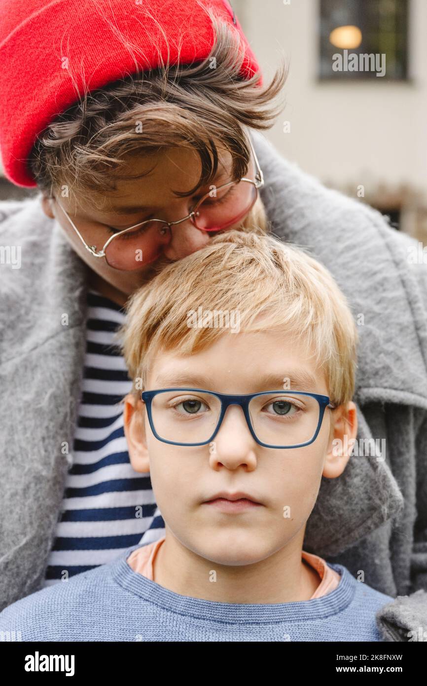 Mutter trägt eine Brille und umarmt den Sohn Stockfoto
