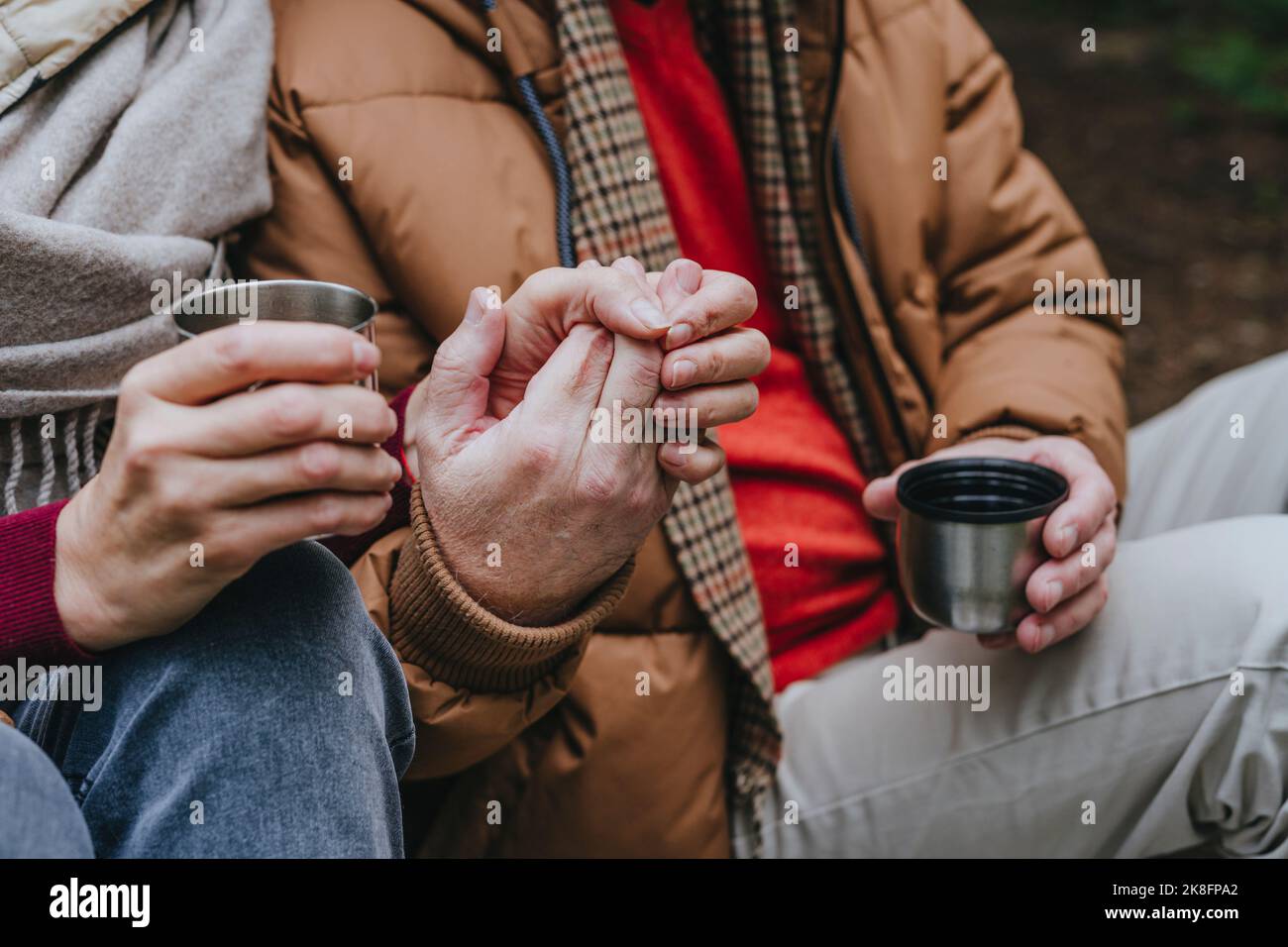 Paar sitzen zusammen mit Händen halten Stockfoto