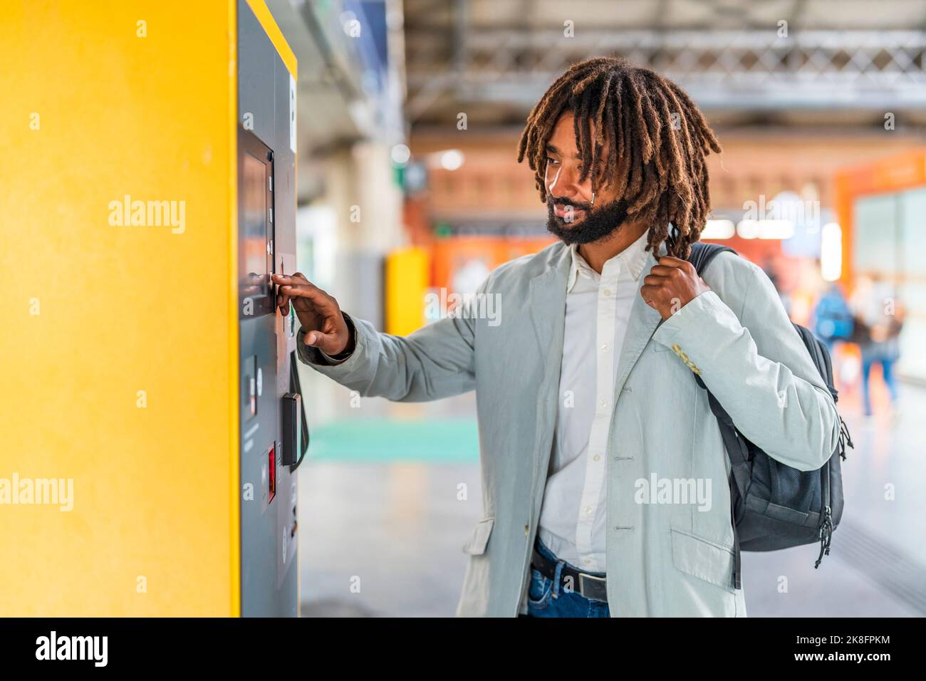 Lächelnder Geschäftsmann, der am Bahnhof ein Touchscreen-Gerät verwendet Stockfoto