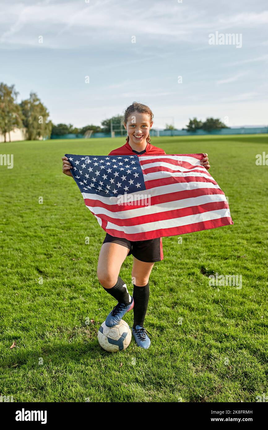 Glückliches Mädchen mit amerikanischer Flagge auf dem Feld Stockfoto