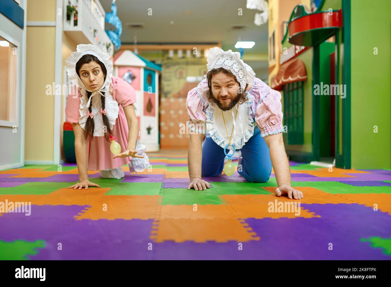 Nette lustige Frau und Mann wie Baby kriechen auf dem Boden Stockfoto