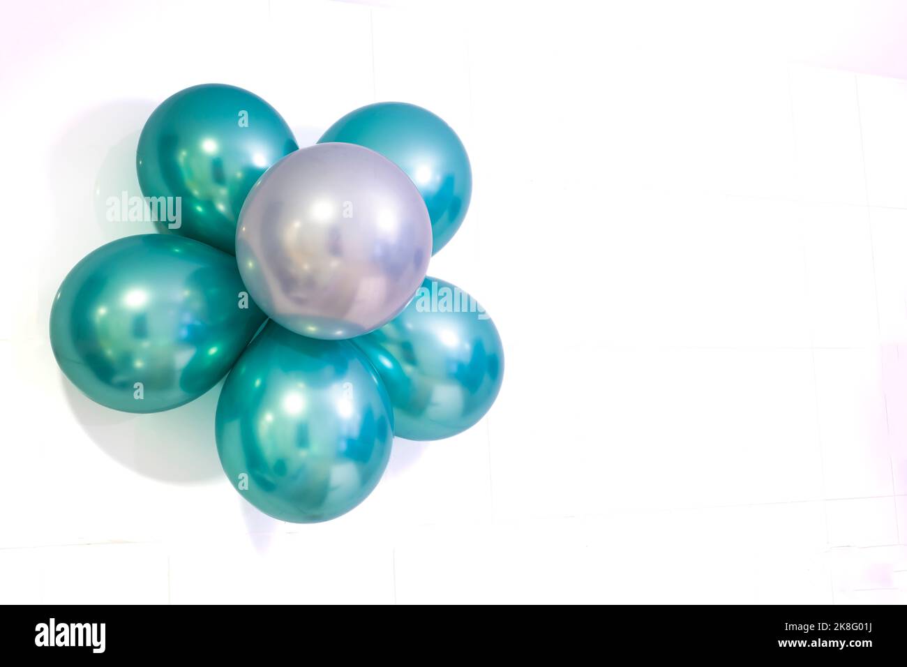 Blume aus Heliumballons in den Metallic-Farben grün und silber, auf weißem Hintergrund, Kopierraum rechts, horizontal Stockfoto