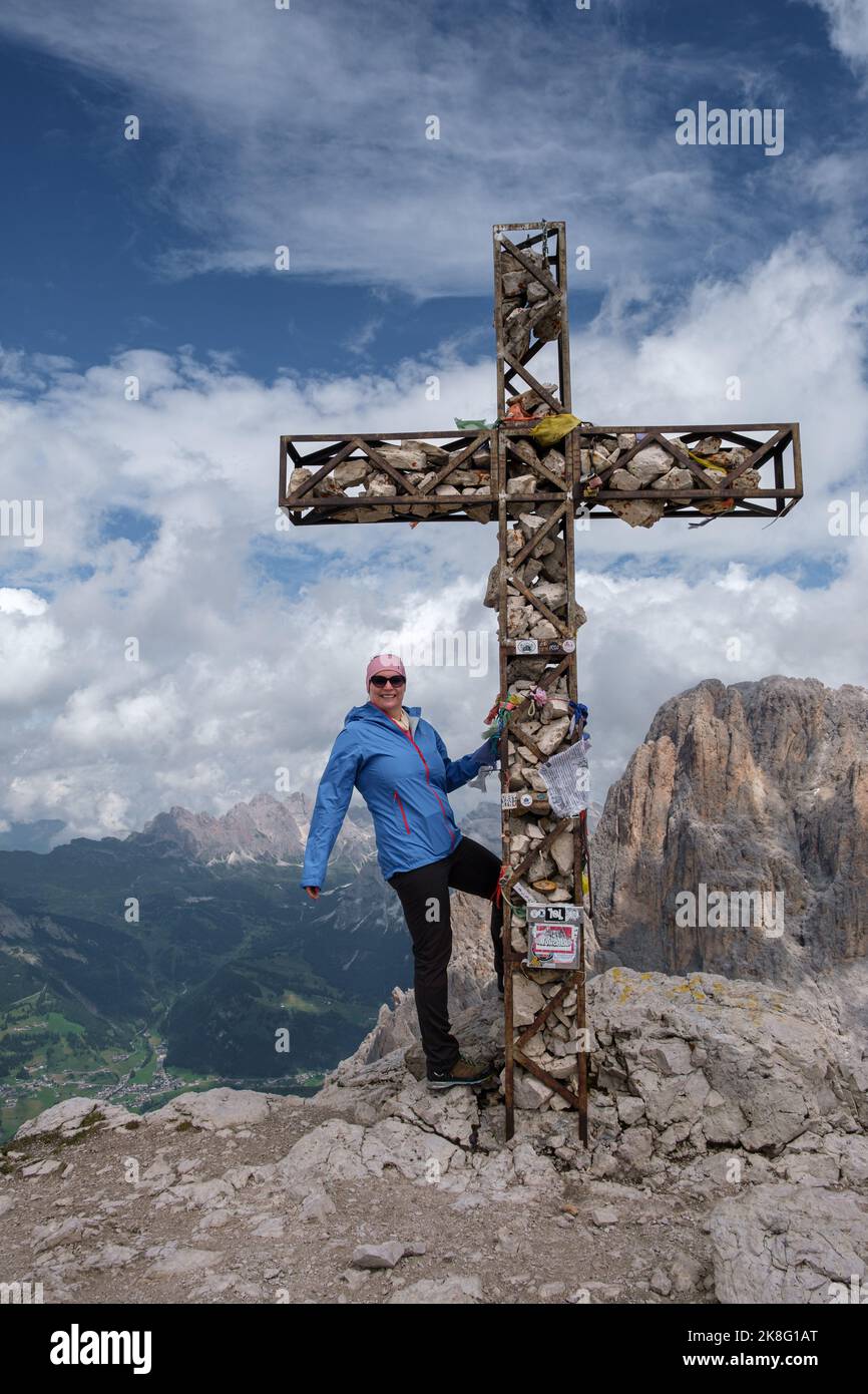 Bergsteiger in den italienischen Dolomiten auf dem Gipfel vom Plattkofel posieren am Gipfelkreuz. Stockfoto