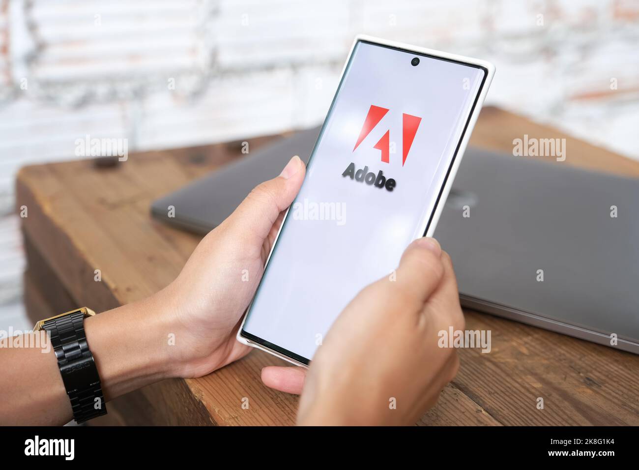 Chiangmai, Thailand, 06. Juni 2021: Frau mit Smartphone-Handy zeigt das Adobe-Logo auf dem Smartphone-Bildschirm Stockfoto