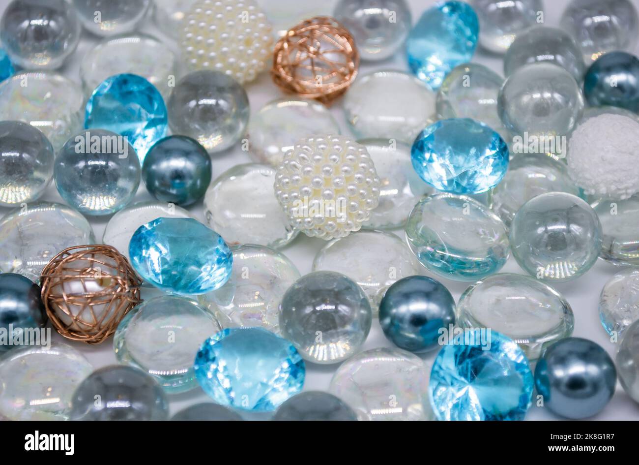 Schöner Hintergrund aus transparenten, hellblauen Glasperlen, Kristallen und weißen Perlen. Speicherplatz kopieren. Stockfoto