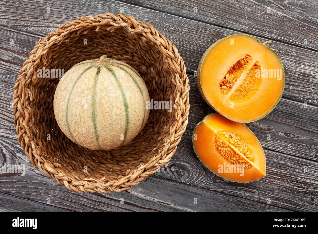 Aufgeschnittene Melone auf Holzhintergrund Draufsicht Stockfoto