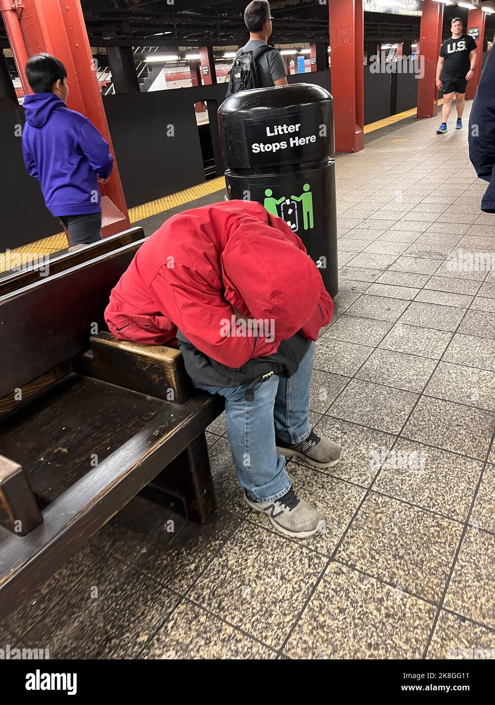 Müder Mann auf einem Platz auf dem Bahnsteig an einer U-Bahnstation in Manhattan, New York City. Stockfoto