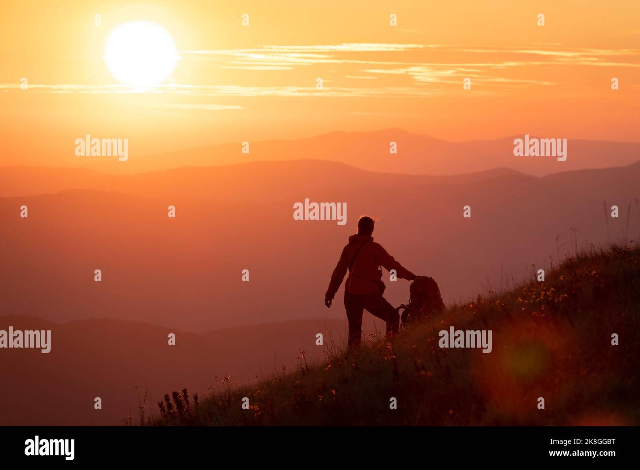 Wanderer Mädchen mit schweren Rucksack Blick auf den Sonnenuntergang hoch in den Bergen. Tolles Outdoor-Urlaub- und Erkundungskonzept. Lebenswerk erhalten Stockfoto