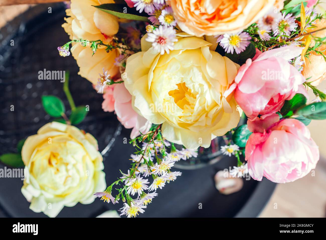 Draufsicht auf frischen Strauß von Rosen Blumen in Vase auf den Tisch gelegt. Nahaufnahme von rosa gelben Blüten. Einrichtung im Sommer. Blumen anordnen Stockfoto
