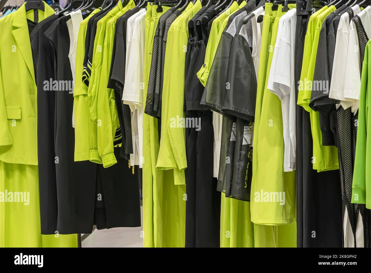 Sammlung weiblicher Kleidung an Kleiderbügeln in der Nähe des Ladens. Modenschau-Raum. Kaufhintergrund Stockfoto