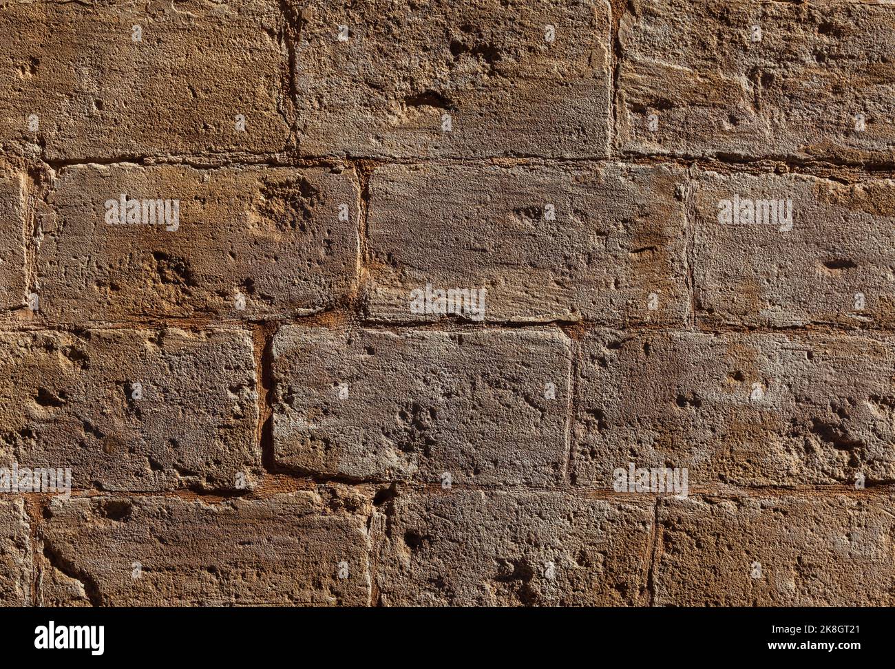 Die abgenutzte Steinmauer im Laufe der Zeit. Eine alte Steinmauer Hintergrund. Stockfoto