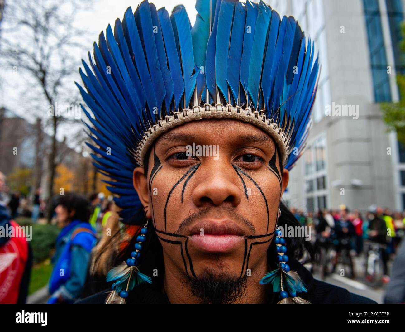 Ein indigener Mann sah während des klimamarsches blaue Federn tragen. Tausende von Menschen versammelten sich während eines von der Climate Coalition (einer nationalen Non-Profit-Organisation, die mehr als 90 Organisationen zum Thema Klimagerechtigkeit zusammenbringt) organisierten klimamarsches vor dem Brüsseler Nordbahnhof, um gegen das Fehlen von Maßnahmen gegen die Klimakrise zu protestieren. Mit diesem märz fordern sie, die Energiekrise mit einer einheitlichen Energiepolitik zwischen den Regionen und dem Bundesland zu bekämpfen, die es Belgien ermöglicht, bis 2050 100 % erneuerbare Energien zu erreichen, und die Agrarkrise zu bekämpfen Stockfoto