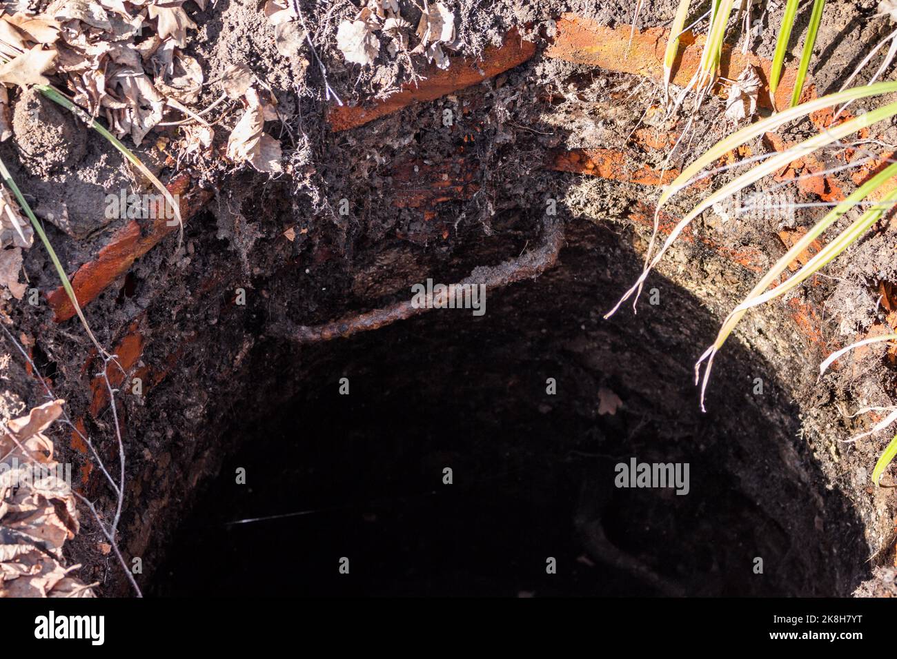 Ungesperrtes altes Ziegelgut, gefährliches Loch im Boden Stockfoto
