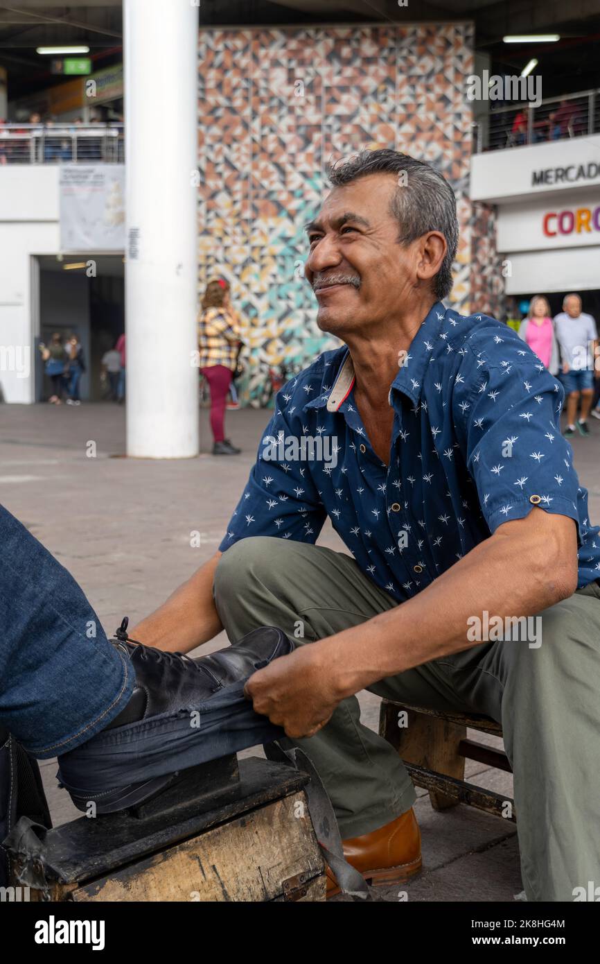 Schuhe in einem Waschbecken mit Seifenwasser. Reinigung der Schuhe auf der Straße, lateinischer alter Mann, Stockfoto