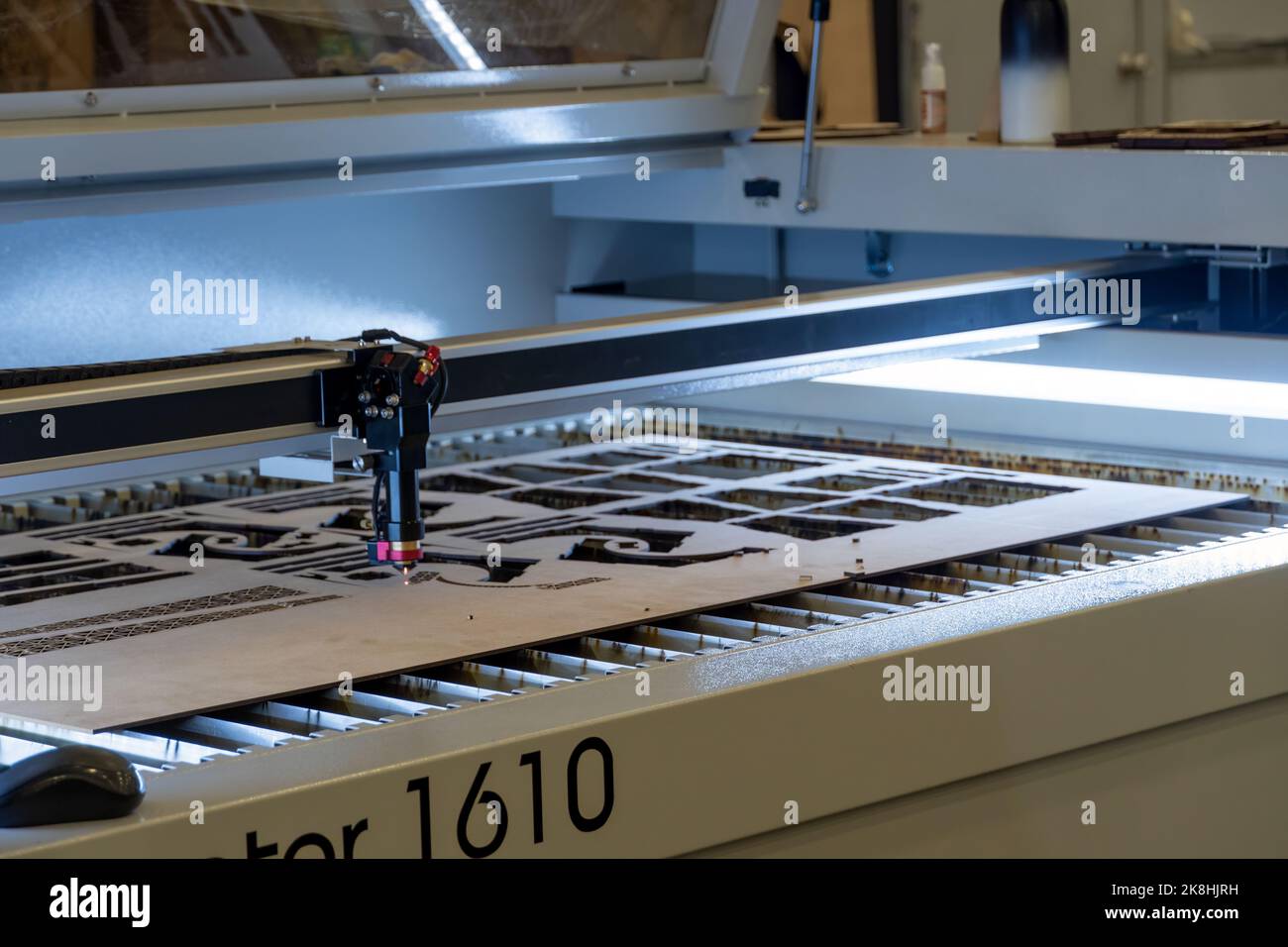 Laserschneidemaschine, Schneiden von Holzplatten, während ein Mann zeichnet den Prozess, mexiko Stockfoto